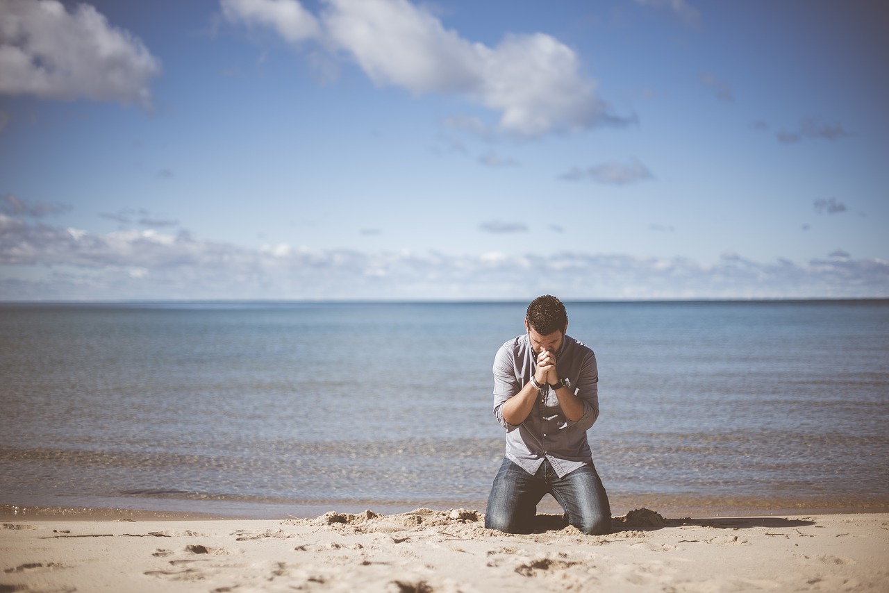 浜辺で祈る男性